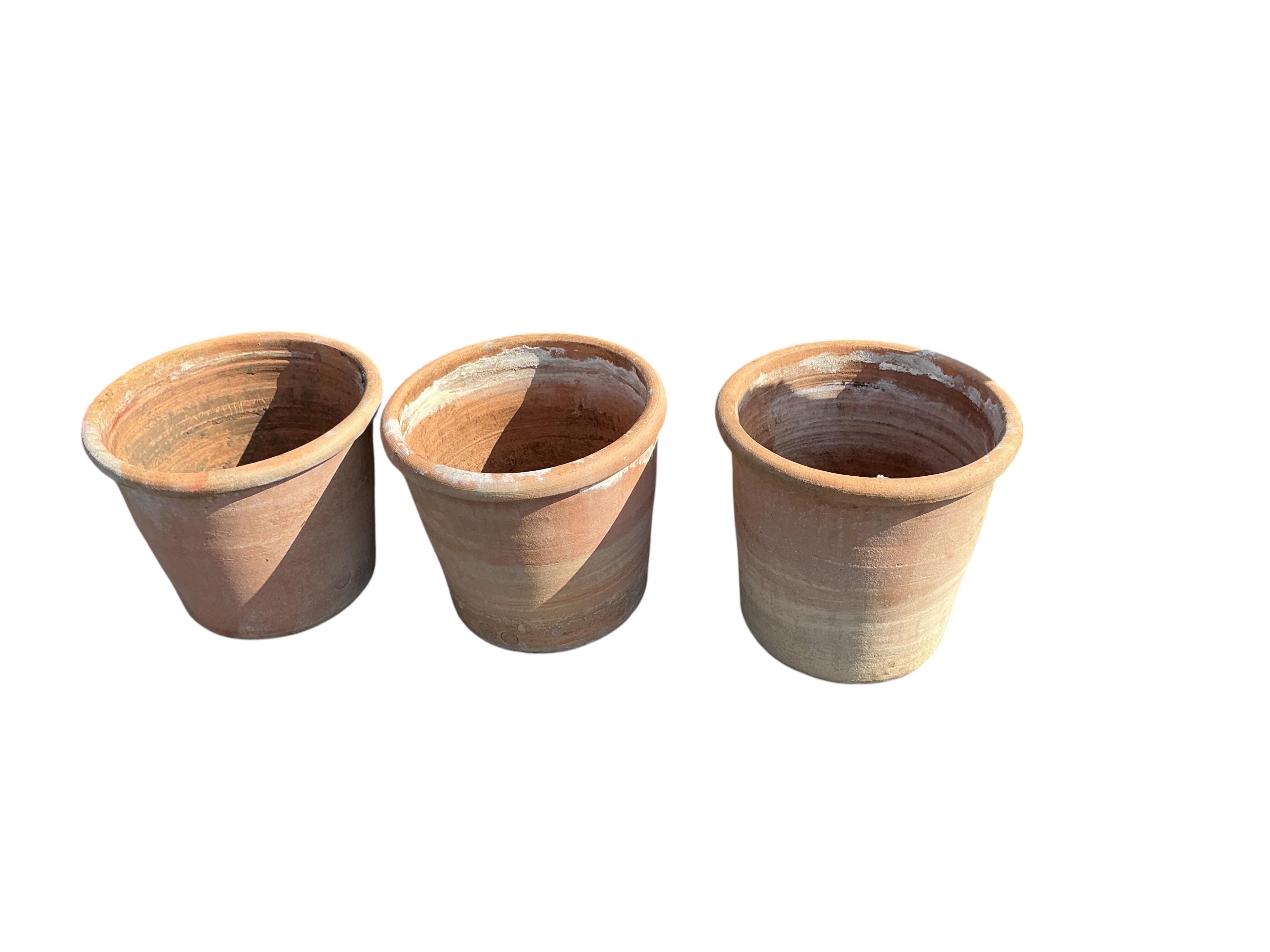 A set of three circular terracotta garden planters, diameter 41cm, height 38cm